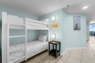 a bedroom with two bunk beds and a table at Grand Panama 1005 - Tower Two - 2 bedroom - Large Deck with Gulf Views by Beach Haven Vacation Rentals in Panama City Beach
