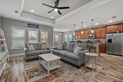 a living room with two couches and a kitchen at Nothin But Time by Beach Haven Vacation Rentals in Panama City Beach