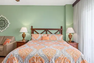 a bedroom with a bed and two lamps and a couch at Origin 0425 - Studio King - On the Pool Deck with Quiet Nature View by Beach Haven Vacation Rentals in Panama City Beach