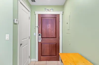 a wooden door in a room with a wooden table at Origin 0425 - Studio King - On the Pool Deck with Quiet Nature View by Beach Haven Vacation Rentals in Panama City Beach