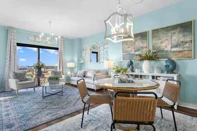 a living room with blue walls and a table and chairs at Origin 0507- One Bedroom - Sunset and Gulf Views! by Beach Haven Vacation Rentals in Panama City Beach