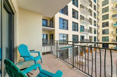 a balcony with two blue chairs and a building at Origin 0508 - One Bedroom - Pool and Gulf Views! by Beach Haven Vacation Rentals in Panama City Beach
