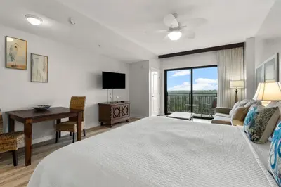 a bedroom with a bed and a desk and a television at Origin 0513 - Studio King - City View with a Great Value by Beach Haven Vacation Rentals in Panama City Beach