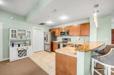 a kitchen with wooden cabinets and a counter top at Origin 0517 - One Bedroom - Partial Gulf View by Beach Haven Vacation Rentals in Panama City Beach