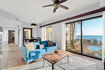 a living room with a blue couch and a view of the ocean at Origin 0524 - One Bedroom - Beautiful Gulf Views! by Beach Haven Vacation Rentals in Panama City Beach