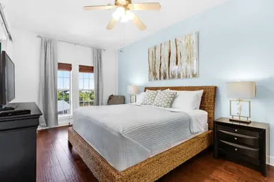 a bedroom with a bed and a ceiling fan at The Village Blue Haven Condo - Private Beach Access Pool & Hot Tub in Rosemary Beach