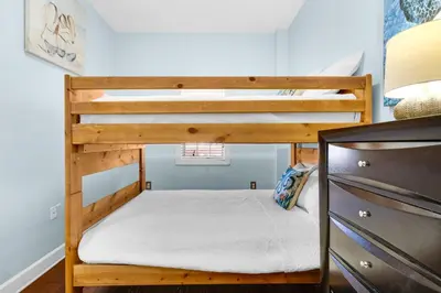 a bunk bed in a small room with a desk at The Village Blue Haven Condo - Private Beach Access Pool & Hot Tub in Rosemary Beach