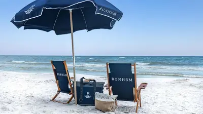 two chairs and an umbrella on the beach at The Village Blue Haven Condo - Private Beach Access Pool & Hot Tub in Rosemary Beach