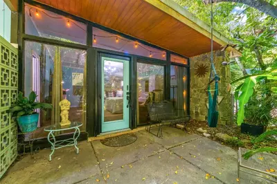 a screened in porch with a glass door at Zen Studio by Beach Haven Vacation Rentals in Panama City Beach