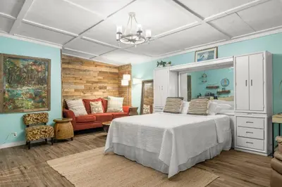 a bedroom with a bed and a living room at Zen Studio by Beach Haven Vacation Rentals in Panama City Beach