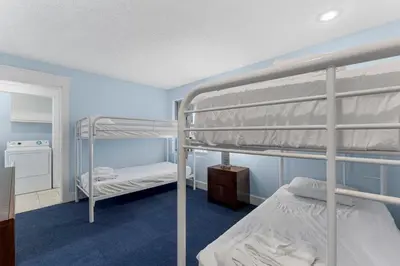a bedroom with two bunk beds and a mirror at Tiki Time 702 by Beach Haven Vacation Rentals in Panama City Beach