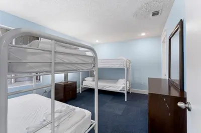 a room with two bunk beds in it at Tiki Time 702 by Beach Haven Vacation Rentals in Panama City Beach