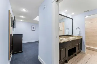 a bathroom with two sinks and a large mirror at Tiki Time 702 by Beach Haven Vacation Rentals in Panama City Beach