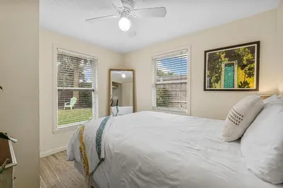 a bedroom with a white bed and two windows at The Yard by Beach Haven Vacation Rentals in Panama City Beach