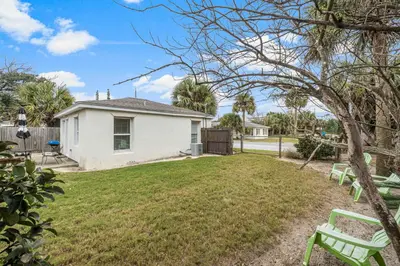 a yard with two green benches in front of a house at The Yard by Beach Haven Vacation Rentals in Panama City Beach