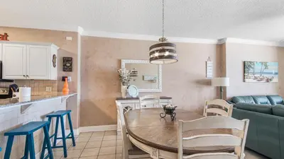 a kitchen and living room with a table and chairs at Emerald Isle 403 by Emerald Coast Retreats in Panama City Beach