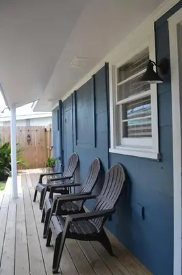 a row of chairs sitting on a porch at Surf Shack - Steps to the beach, lush fenced backyard by Beach Haven Vacation Rentals in Panama City Beach