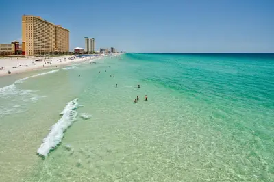 a group of people in the water at the beach at Surf Shack - Steps to the beach, lush fenced backyard by Beach Haven Vacation Rentals in Panama City Beach