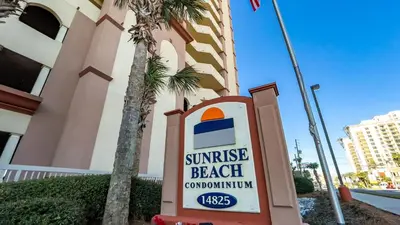a sign for a sunrise beach convention center in front of a building at Sunrise Beach - 1610 by Beach Haven Vacation Rentals in Panama City Beach