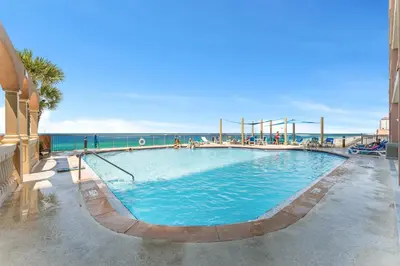 a large swimming pool with the ocean in the background at Sunrise Beach - 1610 by Beach Haven Vacation Rentals in Panama City Beach