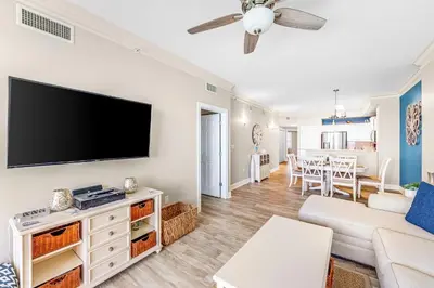 a living room with a flat screen tv on a wall at Sunrise Beach - 1610 by Beach Haven Vacation Rentals in Panama City Beach