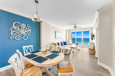 a dining room and living room with an octopus painting on the wall at Sunrise Beach - 1610 by Beach Haven Vacation Rentals in Panama City Beach