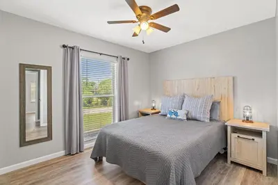a bedroom with a bed and a ceiling fan at Sunny Daze Cottage by Beach Haven Vacation Rentals in Panama City Beach