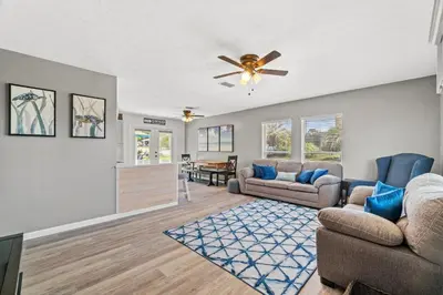 a living room with two couches and a ceiling fan at Sunny Daze Cottage by Beach Haven Vacation Rentals in Panama City Beach
