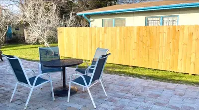 a patio with a table and chairs and a fence at Sunny Daze Cottage by Beach Haven Vacation Rentals in Panama City Beach