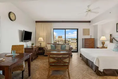 a bedroom with a bed and a living room at Origin 0609 - Studio King - Beautiful Sunset Gulf Views! by Beach Haven Vacation Rentals in Panama City Beach