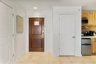 a kitchen with white walls and a door and a counter at Origin 0609 - Studio King - Beautiful Sunset Gulf Views! by Beach Haven Vacation Rentals in Panama City Beach