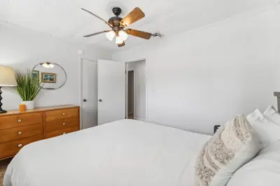 a bedroom with a white bed and a ceiling fan at Summer Haven by Beach Haven Vacation Rentals in Panama City Beach