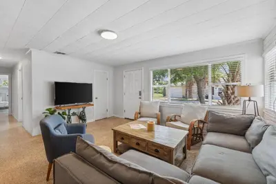 a living room with couches and a table and a tv at Summer Haven by Beach Haven Vacation Rentals in Panama City Beach