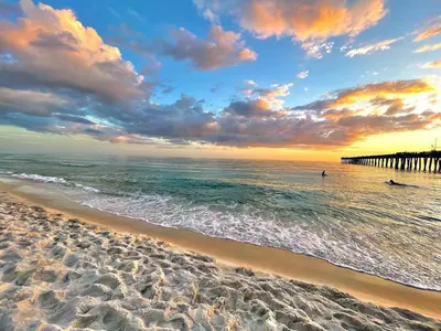 a sandy beach with a pier in the ocean at Sterling Breeze 1205 by Beach Haven Vacation Rentals in Panama City Beach