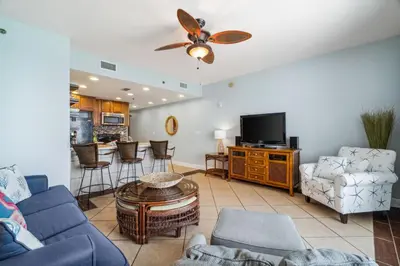 a living room with a couch and a tv at Sterling Breeze 1205 by Beach Haven Vacation Rentals in Panama City Beach