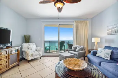 a living room with a blue couch and a tv at Sterling Breeze 1205 by Beach Haven Vacation Rentals in Panama City Beach