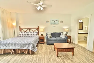 a bedroom with a bed and a couch at Origin 0623 - Studio King- Amazing Value - City View by Beach Haven Vacation Rentals in Panama City Beach