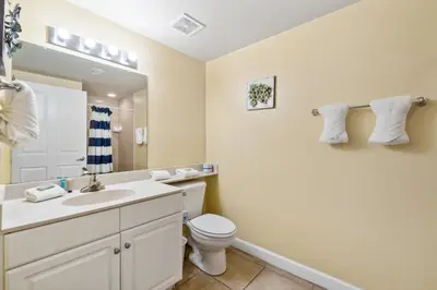 a bathroom with a sink and a toilet and a mirror at Shores of Panama 2219 by Beach Haven Vacation Rentals in Panama City Beach
