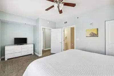 a bedroom with a white bed and a ceiling fan at Shores of Panama 2219 by Beach Haven Vacation Rentals in Panama City Beach