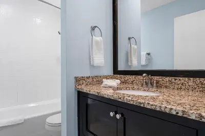 a bathroom with a sink and a mirror and a toilet at Sharkys Retreat 701 by Beach Haven Vacation Rentals in Panama City Beach