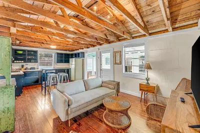 a living room with a couch and a kitchen at Sea Shed by Beach Haven Vacation Rentals in Panama City Beach