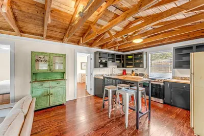 a kitchen with green cabinets and a wooden ceiling at Sea Shed by Beach Haven Vacation Rentals in Panama City Beach