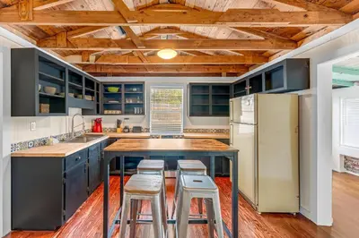a kitchen with a large island with stools in it at Sea Shed by Beach Haven Vacation Rentals in Panama City Beach