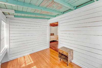 an empty room with a wooden wall and a bench at Sea Shed by Beach Haven Vacation Rentals in Panama City Beach
