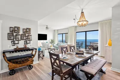 a dining room and living room with a table and chairs at Origin 1706 - PENTHOUSE - Three Bedroom- Stylish Gulf View by Beach Haven Vacation Rentals in Panama City Beach