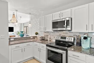 a kitchen with white cabinets and a stove top oven at Origin 1706 - PENTHOUSE - Three Bedroom- Stylish Gulf View by Beach Haven Vacation Rentals in Panama City Beach