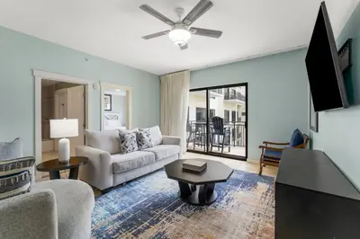 a living room with a couch and a tv at Origin 1408 - Two Bedroom - Pool and Gulf View in Panama City Beach