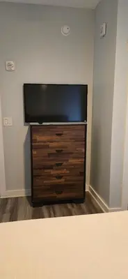 a flat screen tv sitting on top of a wooden dresser at Origin 1332 - One Bedroom - Pool and Gulf Views by Beach Haven Vacation Rentals in Panama City Beach