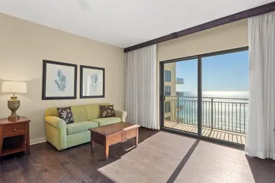 a living room with a couch and a balcony at Origin 1320 - Studio King Gulf View- Amazing Gulf View by Beach Haven Vacation Rentals in Panama City Beach