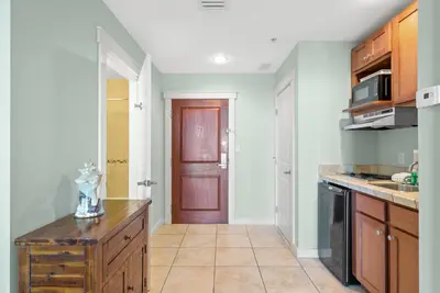 a kitchen with a wooden counter and a door at Origin 1319 - Studio King - City View - Amazing Value by Beach Haven Vacation Rentals in Panama City Beach